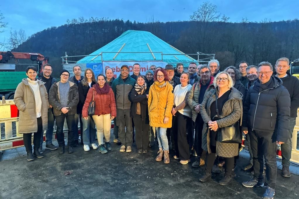 Spatenstich ohne Spaten: Bei einem Richtfest wurde der Baubeginn der neuen Kita am Elzpark offiziell von Stadtverwaltung, beteiligten Firmen und Architekten markiert. Im Hintergrund ist bereits der Rohbau der ersten Jurte zu erkennen. ©Stadt Mosbach Spatenstich ohne Spaten: Bei einem Richtfest wurde der Baubeginn der neuen Kita am Elzpark offiziell von Stadtverwaltung, beteiligten Firmen und Architekten markiert. Im Hintergrund ist bereits der Rohbau der ersten Jurte zu erkennen. ©Stadt Mosbach