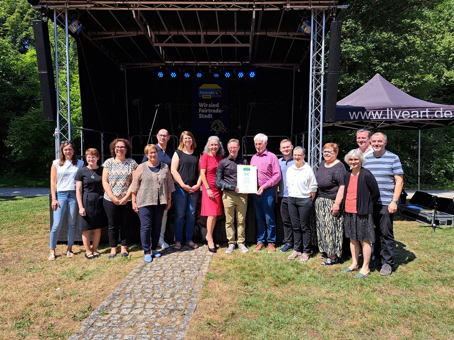 Manfred Holz, Ehrenbotschafter der Kampagne "Fairtrade Towns", überreicht dem Mosbacher Oberbürgermeister Julian Stipp, Mitarbeiter*innen der Stadtverwaltung und Kampagnen-Unterstützern die Urkunde zur "Fairtrade Town"-Mosbach. ©Stadt Mosbach 